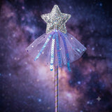 A glittery star wand with a sparkling silver star topper, a lavender tulle skirt with blue sequins, and a purple wand handle, set against a starry purple and blue galaxy background.